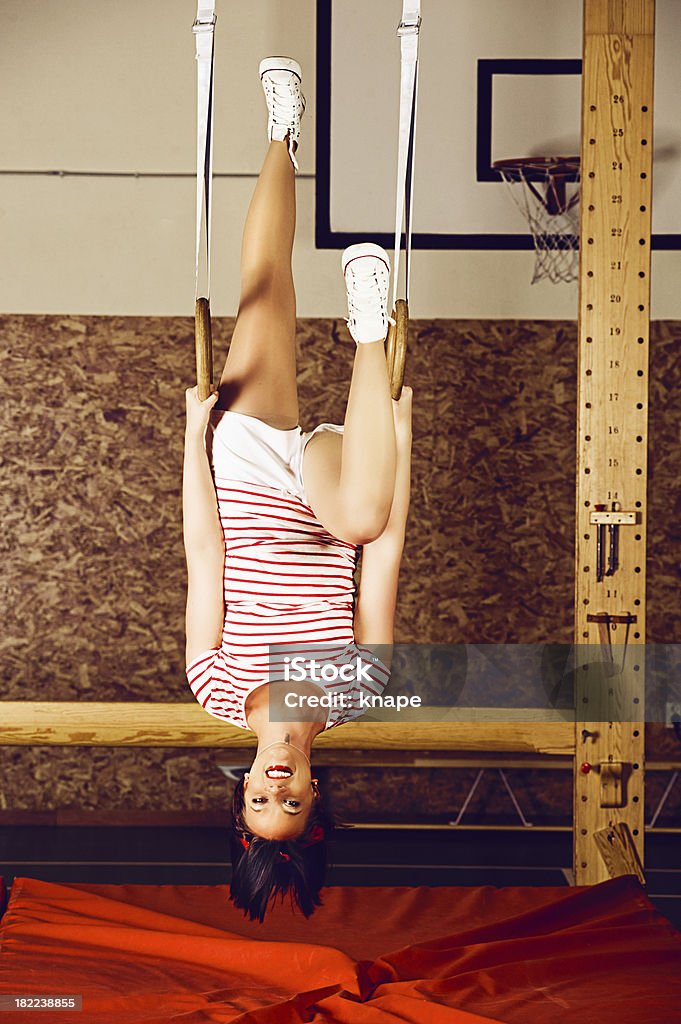 Mujer colgado hacia abajo en anillas de gimnasia - Foto de stock de 20 a 29 años libre de derechos