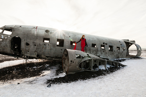 A young woman posing in Solheimasandur the plane wreck view during winter snow