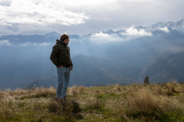 istock Young man explores mountain meadow above valley and clouds 1822404630