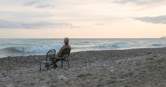 Senior man relaxes on beach chair at sunrise