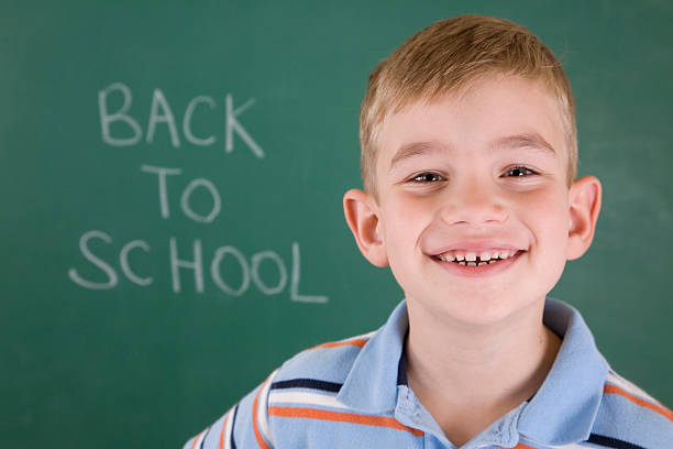 istock Cute Smiling Student at Chalk Board saying Back To School 182243417
