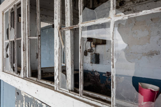 istock Looking through broken windows into a security office in an abandoned factory in the rural south 1822434422
