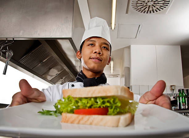 chefe de cozinha e pelo formando - chef trainee cooking teenager imagens e fotografias de stock