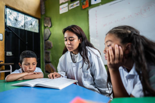 istock Teacher reading book to child students in school classroom 1822441463