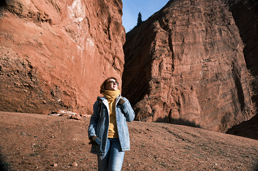 Female tourist is hiking in canyon in winter