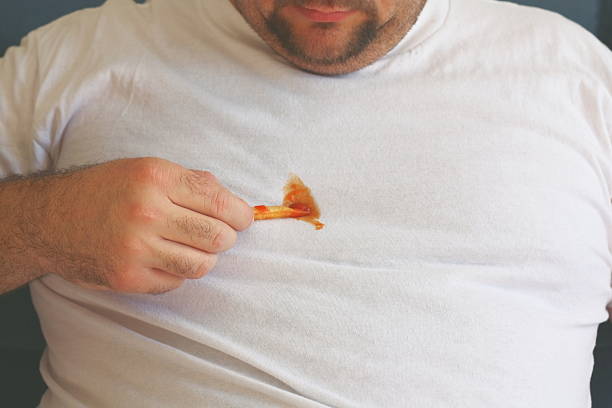 A man decides to try and clean his shirt by scraping off the ketchup with a french fry.  Sometimes you have to do what you have to do!