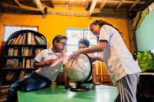 Child students studying the globe in the library