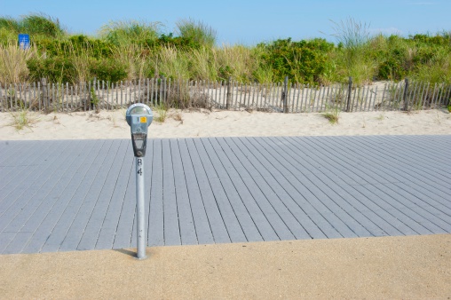 a parking meter at a New Jersey beach with sand dune in background.