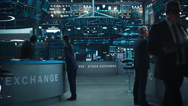 Stock Exchange Traders Working in an Office with Multiple Computer Screens with Real-Time Stocks, Commodities and Exchange Market Charts. Managers Work for Investment Banks, International Companies