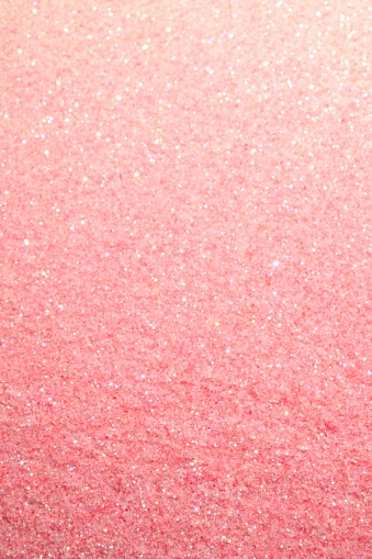 XXXL photo of pink sugar glitter that looks like sparkly pink sand with selective focus to increase sparkle on upper portion.