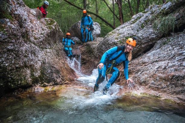 Diverse Friends Walking Through Canyons in Canyoning Adventure