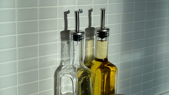 Tall olive oil bottles and various spice jars in the kitchen