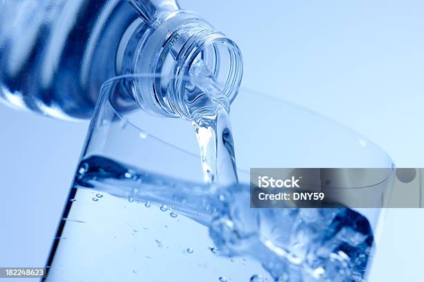Wasser Aus Der Flasche In Glas Gegossen Wird Stockfoto und mehr Bilder von Wasserflasche - Wasserflasche, Eingießen, Spritzendes Wasser
