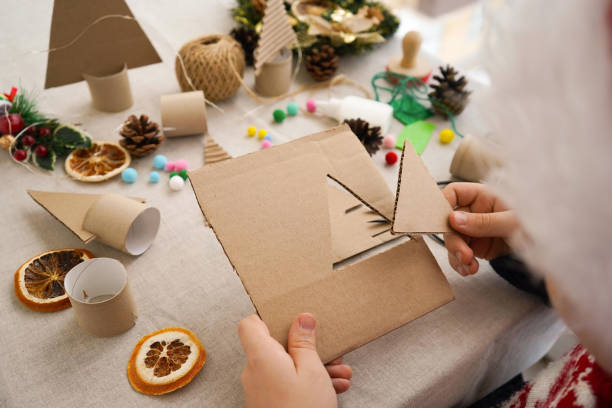 istock Step-by-step instructions on how to make a Christmas tree out of cardboard. Step 1 Cut out the triangle. Zero waste concept. 1822486475