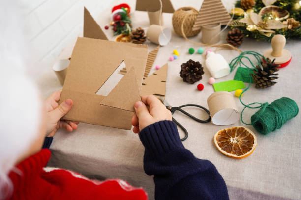 istock Step-by-step instructions on how to make a Christmas tree out of cardboard. Step 1 Cut out the triangle. Over shoulder view. Zero waste concept. 1822486996