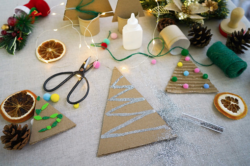 A creative handmade little Christmas tree of cardboard on wooden backround. eco-friendly and zero waste concept
