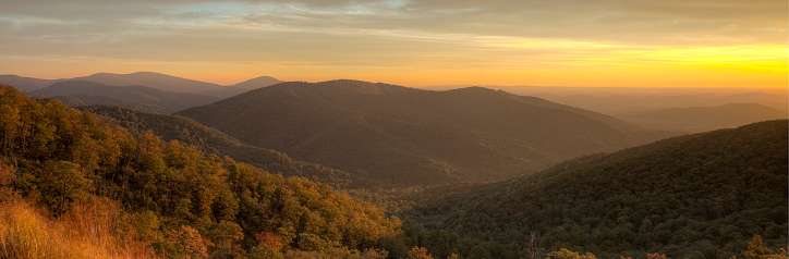 As the sun sets, a brilliant orange and yellow sky lights the Blue Ridge Mountains as nighttime approaches.  Photo was taken on the Skyline Drive in Shenandoah National Park.