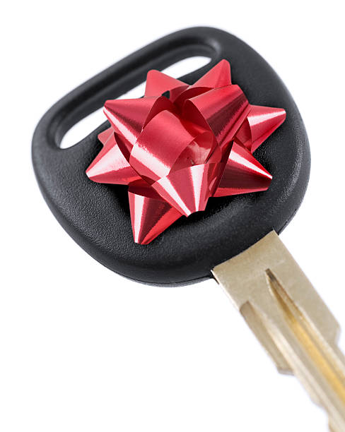 Close-up of car key with a red bow on it stock photo