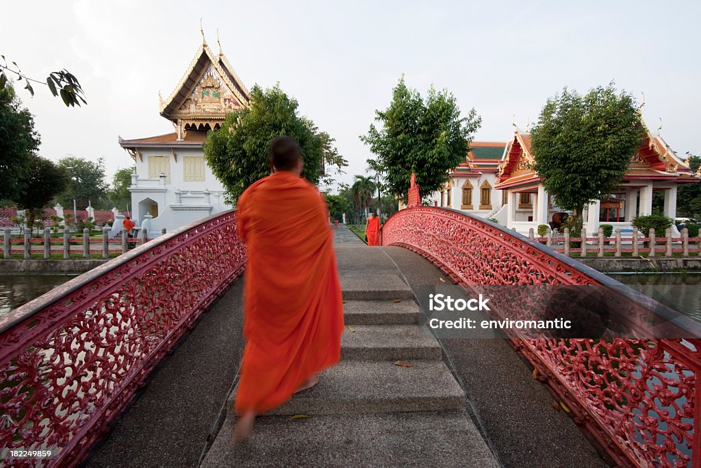 Buddhist monks at the Marble Temple (Wat Benchamapophit). Buddhist monks crossing an old wrought iron bridge, within the grounds of the Marble Temple (Wat Benchamabophit), Bangkok, Thailand after collecting alms in the early morning.  Bangkok Stock Photo