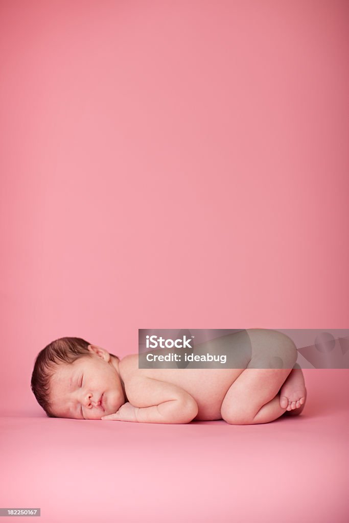 Newborn Baby Girl Sleeping Peacefully on Pink Background Color photo of a beautiful newborn baby girl sleeping peacefully on a pink background. Composed with room for text above. 0-1 Months Stock Photo