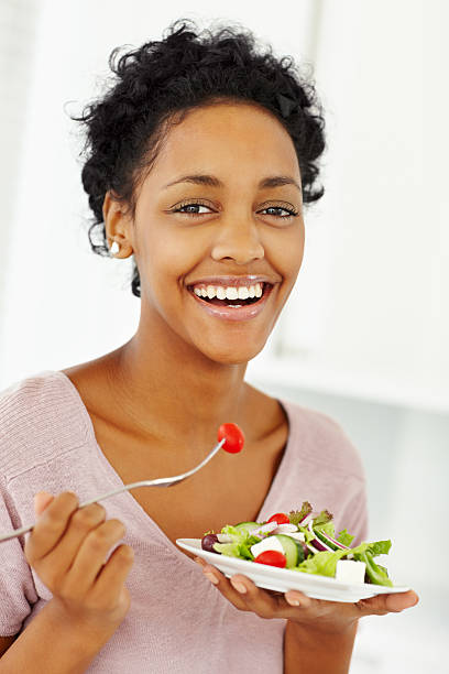 istock Laughing young lady eating salad 182251257