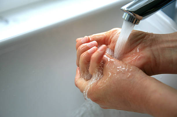 Close up shot of washing hands under running water stock photo