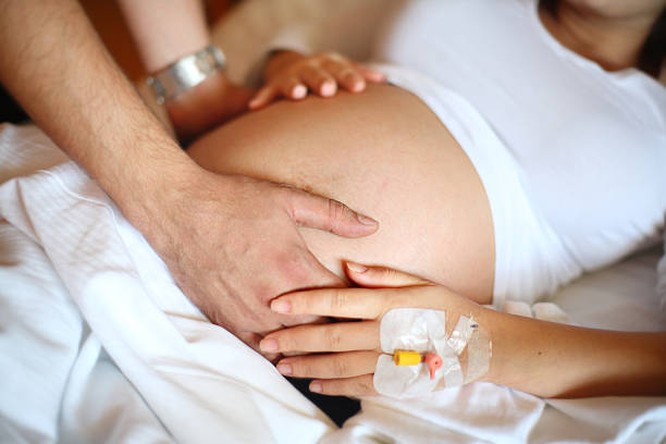 schwangere frau und ihr ehemann - human pregnancy abdomen naked human hand stock-fotos und bilder