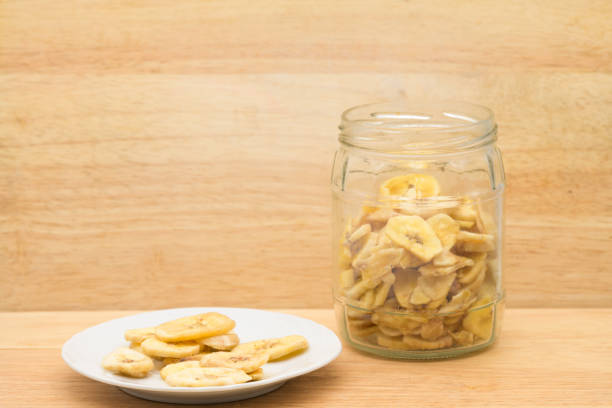 Organic food in the zero-waste store. Food storage in the kitchen for a low-waste lifestyle. Dried bananas in glass jars. Environmentally friendly shopping in a plastic-free grocery store. alimentos ecológicos en tienda residuo cero. almacenamiento de alimentos en la cocina para un estilo de vida de bajo desperdicio. plátanos secos en frascos de vidrio. compras respetuosas con el medio ambiente en una tienda de comestibles sin plástico.