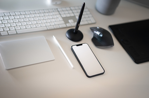 Electronic devices. Smartphone blank screen mockup. White table. Graphic designer tools. Tom view.