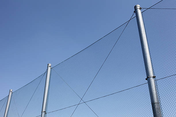 istock metal wire fence with blue sky in background 182253256