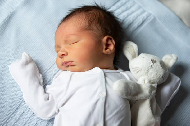 istock Newborn baby with a soft toy bunny on a white background. 1822541463
