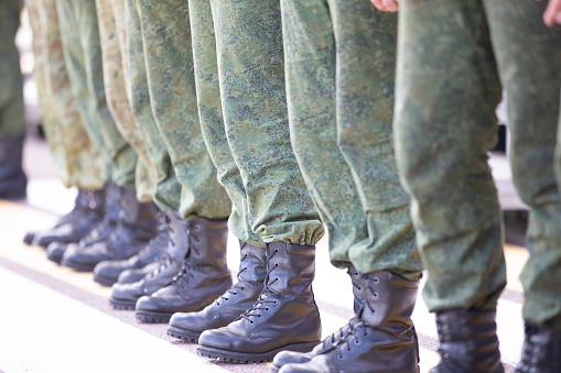 Line up soldiers in protective clothing and boots. They are sent to war or training.