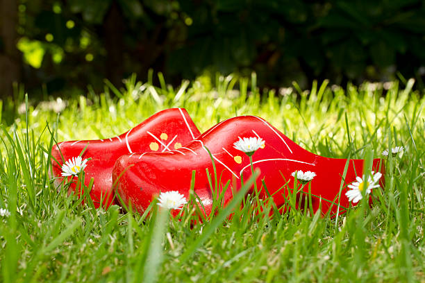 Dutch cheese girl in a red dress and clogs; Gouda, Netherlands