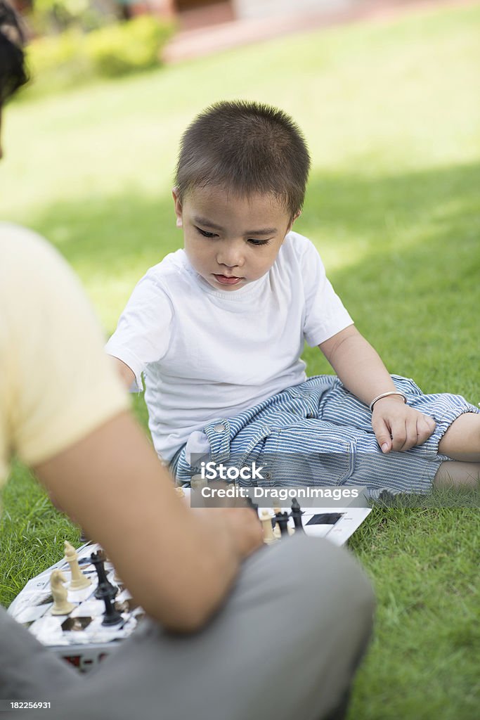 Intelligent cutie Vertical image of a little boy playing chess with his father on the foreground Adult Stock Photo