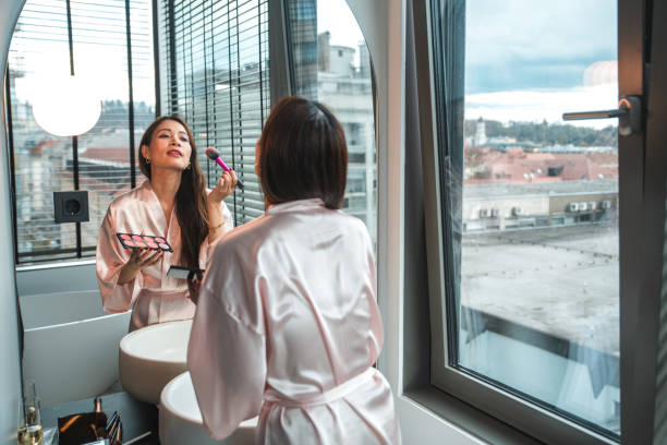 Asian Woman Applying Makeup in Silk Robe