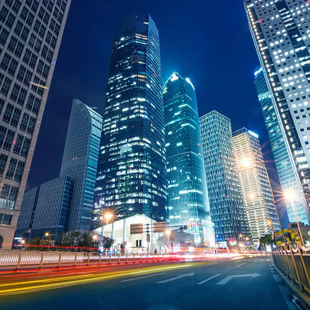 Photo of light trails on the street with modern building