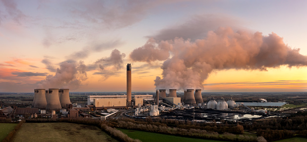Drax Power Station, Selby, UK - November 29, 2023.  Aerial panoramic landscape of Drax coal fired power station in Yorkshire, UK at sunset with coal stack and biofuel storage tanks for cleaner electricity generation