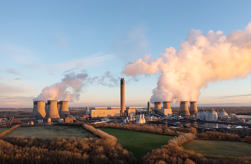 Drax Power Station, Yorkshire, UK - November 29, 2023. Drax coal fired power plant in North Yorkshire, UK with coal stack and Biomass storage tanks at sunset with copy space