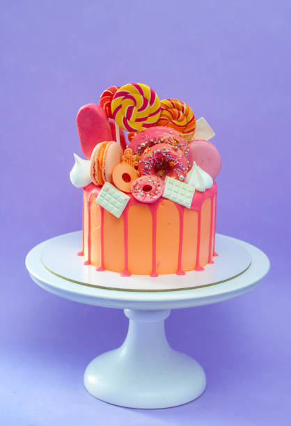 istock Tasty orange cake with sweets on plain purple background 1822581439