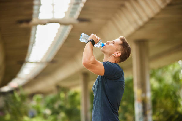istock Male runner under bridge in the city drinking water 1822591248