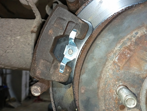 Repair of the brake system of the car. Replacement of old brake pads in old rusty calipers.