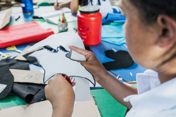 Close-up of a student cutting drawing in school classroom