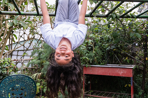 Portrait of a girl upside down in the school playground
