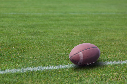 American rugby ball on the grass in the stadium