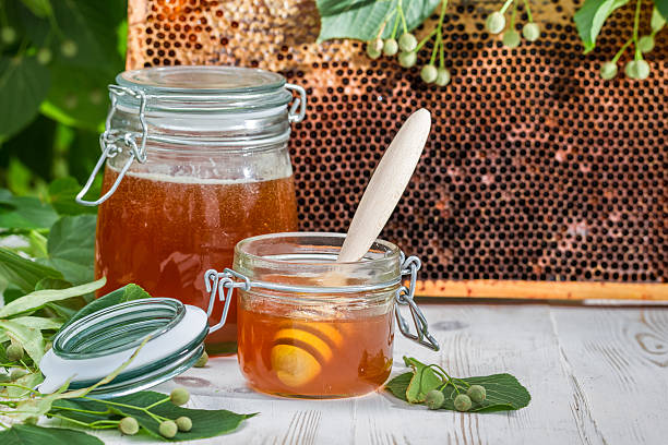 istock Honey in a jar and honeycomb with linden tree 182262301