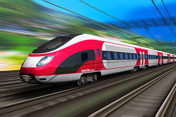 Railroad travel and railway tourism transportation industrial concept: scenic summer view of high speed passenger train on tracks with motion blur effect