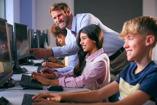 istock Multi-Cultural Group Of Secondary Or High School Students At Computers In IT Class With Male Teacher 1822630557