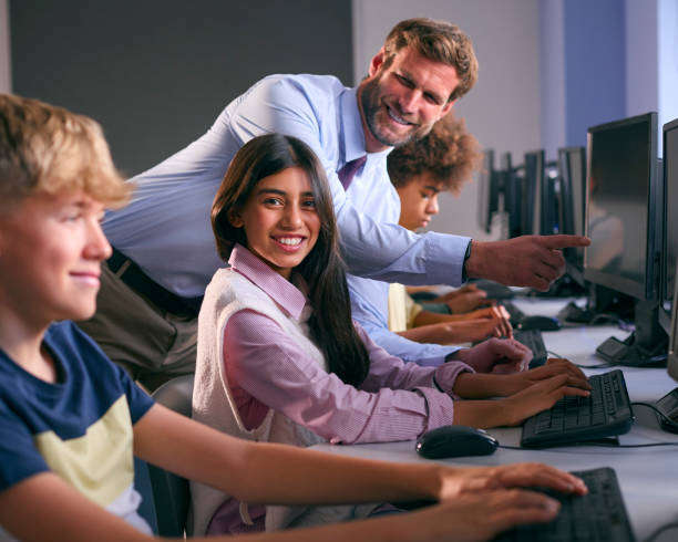istock Multi-Cultural Group Of Secondary Or High School Students At Computers In IT Class With Male Teacher 1822630565