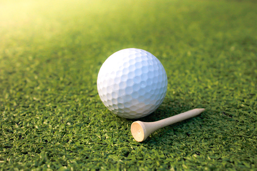 The image of the golf ball and tee placed on artificial grass is not prepared for playing sports.