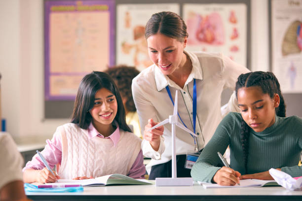 istock Female Teacher Helping Secondary Or High School Students Studying Wind Turbines In Science Class 1822645779